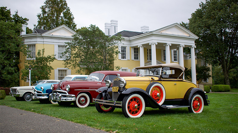 Outdoor photo of vintage cars on lawn